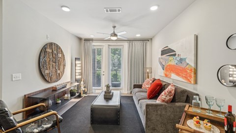 A living room with a grey couch, a wooden coffee table, and a painting on the wall.